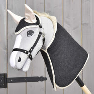 Ensemble Bleu Denim de Hobby Horse LarDen avec Hobby Horse fait main, tête en denim bleu et bâton en bois, formant une décoration charmante qui se détache sur un fond de panneaux en bois clair.