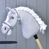 Hobby Horse LarDen „Halfter grau mit pink Fell“ mit grauem Plüschpferd, weißer Mähne und grauem Halfter, an einem Holzstab befestigt, vor grauer Holzpaneelwand.
