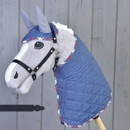Set Jeans Hobby Horse von Hobby Horse LarDen mit grauem Pferd, blauer gesteppten Decke und passender Fliegenhaube mit kariertem Besatz, alles auf einem Holzstock vor grauem Holz-Hintergrund.