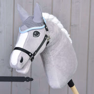 Ohrenkappe gehäkelt grau von Hobby Horse LarDen auf einem plüschigen grauen Hobby Horse mit weißer Mähne und schwarzem Zaumzeug, auf einem Holzstab vor einer hellen Holzwand.