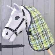 Gros plan sur un jouet Hobby Horse gris sur bâton avec licol noir et couverture d'écurie Citron Bleu de Hobby Horse LarDen, sur fond en bois.