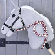 Hobby Horse LarDen Hobby Horse - Führstrick Knitted Maroon mit grauem Filzkopf, schwarzem Zaumzeug für Hobby Horse und handgestricktem kastanienrot-weißem Führstrick, auf einem Holzstab vor einer grauen Holzwand.