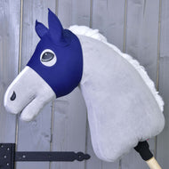 Maske LarDen von Hobby Horse LarDen ist ein graues Plüsch-Hobby Horse mit blauem Stoffzaumzeug und weißer Mähne auf einem Holzstab, ideal als fantasievolles PES-Spielzeug, gezeigt vor einer grauen Holzwand.