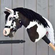 Hobby Horse Oreo with a loose black yarn mane, white fringe and black halter with silver rings, side view