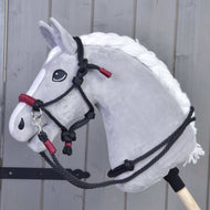 Seilset Maroon von Hobby Horse LarDen vor einer grauen Holzwand, mit bordeauxfarbenen Seilen für Hobby Horses.