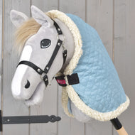 Sky blue quilted stable blanket with white trim worn by a grey Hobby Horse