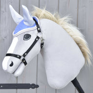 Die Ohrenkappe Light Violett von Hobby Horse LarDen wird auf einem plüschigen Hobby Horse mit hellgrauem Körper, weißer Mähne und schwarzem Zaumzeug vor Holz-Hintergrund gezeigt.