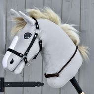 Cordéo Chocolat de Hobby Horse LarDen avec Hobby Horse gris en peluche, bride noire et crinière en corde crème sur un bâton en bois, présenté devant un fond de panneaux en bois gris.