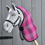 Hobby Horse gris de Hobby Horse LarDen avec bride noire et Couverture d'écurie rose, monté sur un bâton en bois et présenté devant un mur en bois gris.