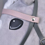Nahaufnahme von Hobby Horse LarDen „Komplettes Kunstlederzaumzeug Grau mit Pink Stirnriemen“ auf einem Plüschpferd mit schwarzem gesticktem Auge und detaillierten Riemen, die mit einer Metallniete befestigt sind.