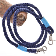 Seilset Dark Blue von Hobby Horse LarDen mit aufgewickeltem dunkelblauem Führstrick mit Metallverschlüssen an beiden Enden, jeweils mit leuchtend blauem Garn umwickelt, präsentiert auf einem hellbraunen Holzast, ein stilvolles Reitzubehör.