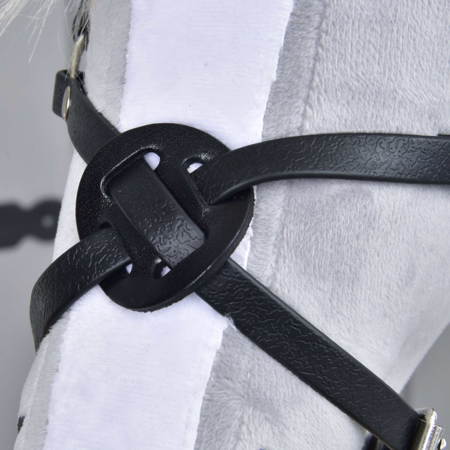 Nahaufnahme von Reithalfter Mexico Schwarz von Hobby Horse LarDen mit einem dekorativen Knoten aus schwarzem Kunstleder, präsentiert auf einer weißen Plüschoberfläche – möglicherweise Teil eines Geschirrs oder Zaumzeugs für Hobby Horses.