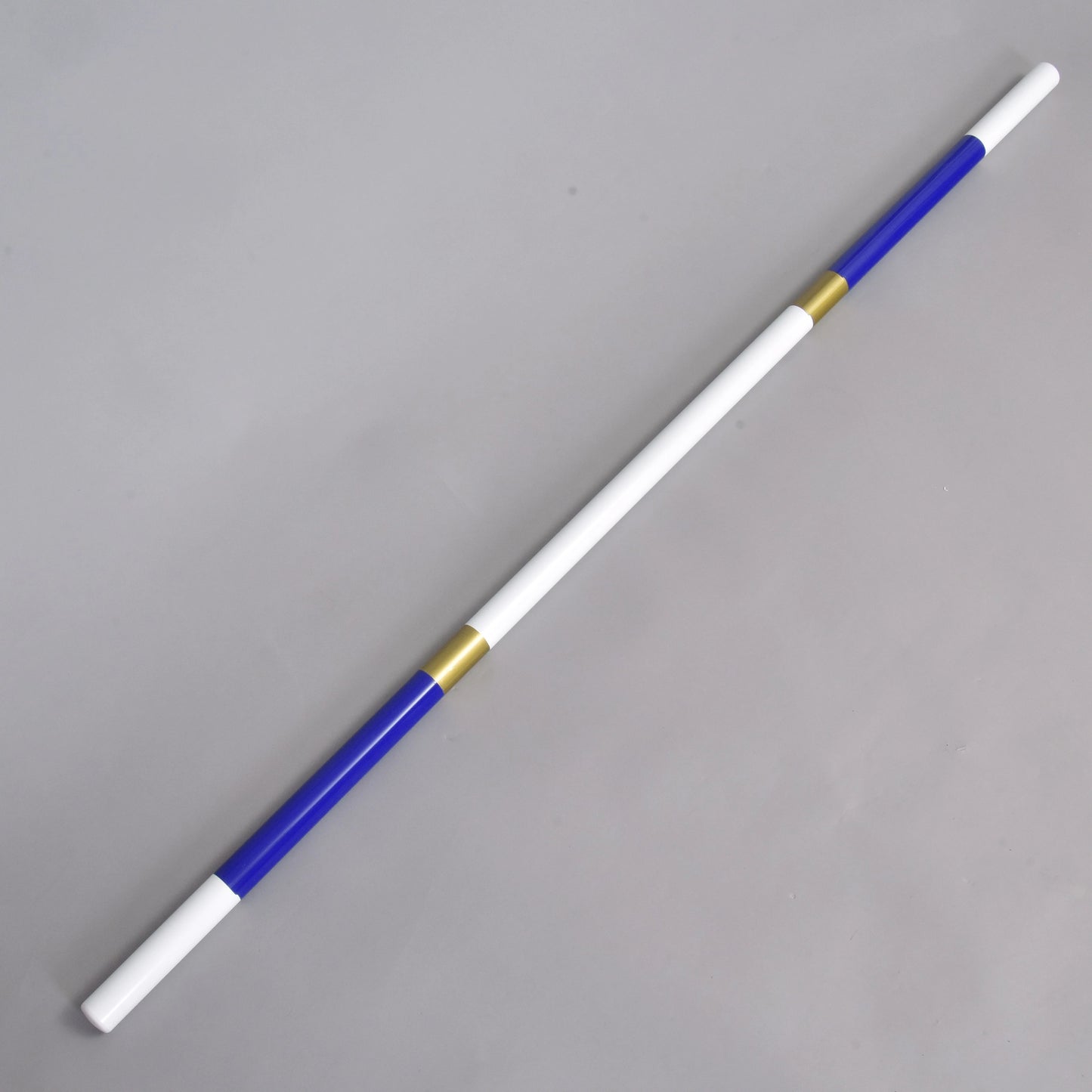 Jump pole blue-gold de Hobby Horse LarDen, barre légère en PVC enduit de 32 mm avec extrémités bleues, sections centrales blanches et deux anneaux dorés. Elle présente des segments alternés blancs, bleus et dorés et est présentée en diagonale sur fond gris clair.