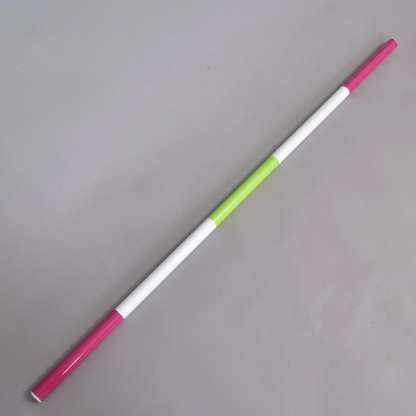 Hindernisstange Rosa-grün von Hobby Horse LarDen, eine leichte Stange mit 32 mm Durchmesser mit abwechselnd rosa, weißen und einem einzelnen grünen Abschnitt, diagonal vor schlichtem grauem Hintergrund.