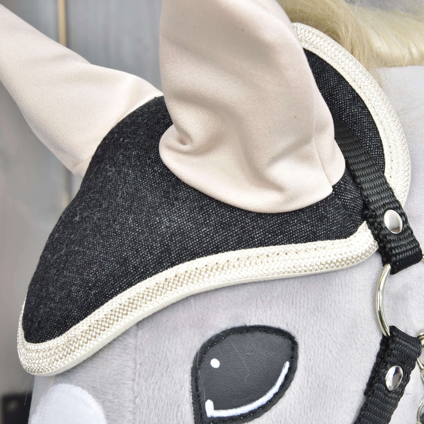 Nahaufnahme des Kopfes des Hobby Horse LarDen Set Blue Denim mit schwarzem Zaumzeug mit weißer Borte, cremefarbenen Ohren, glatter grauer Oberfläche und gesticktem Auge – eine niedliche Dekoration für Pferdeliebhaber.