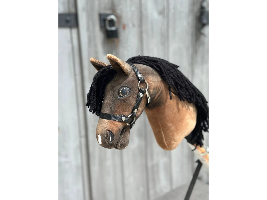 The Hobby Horse Morgan with Black Halter - size XS by Hobby Horse LarDen features a handmade brown plush head, black yarn mane, and black halter, set against a rustic wooden background for an elegant look.