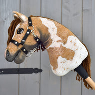 Hobby Horse Biscuit in Seitenansicht, braun-weißes Plüsch-Hobby-Horse mit schwarzem Halfter