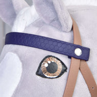 Close-up of a Hobby Horse LarDen toy, showing the Complete bridle with noseband Brown Purple: a detailed fabric eye, dark purple leatherette bridle, beige strap, and soft light grey fur.