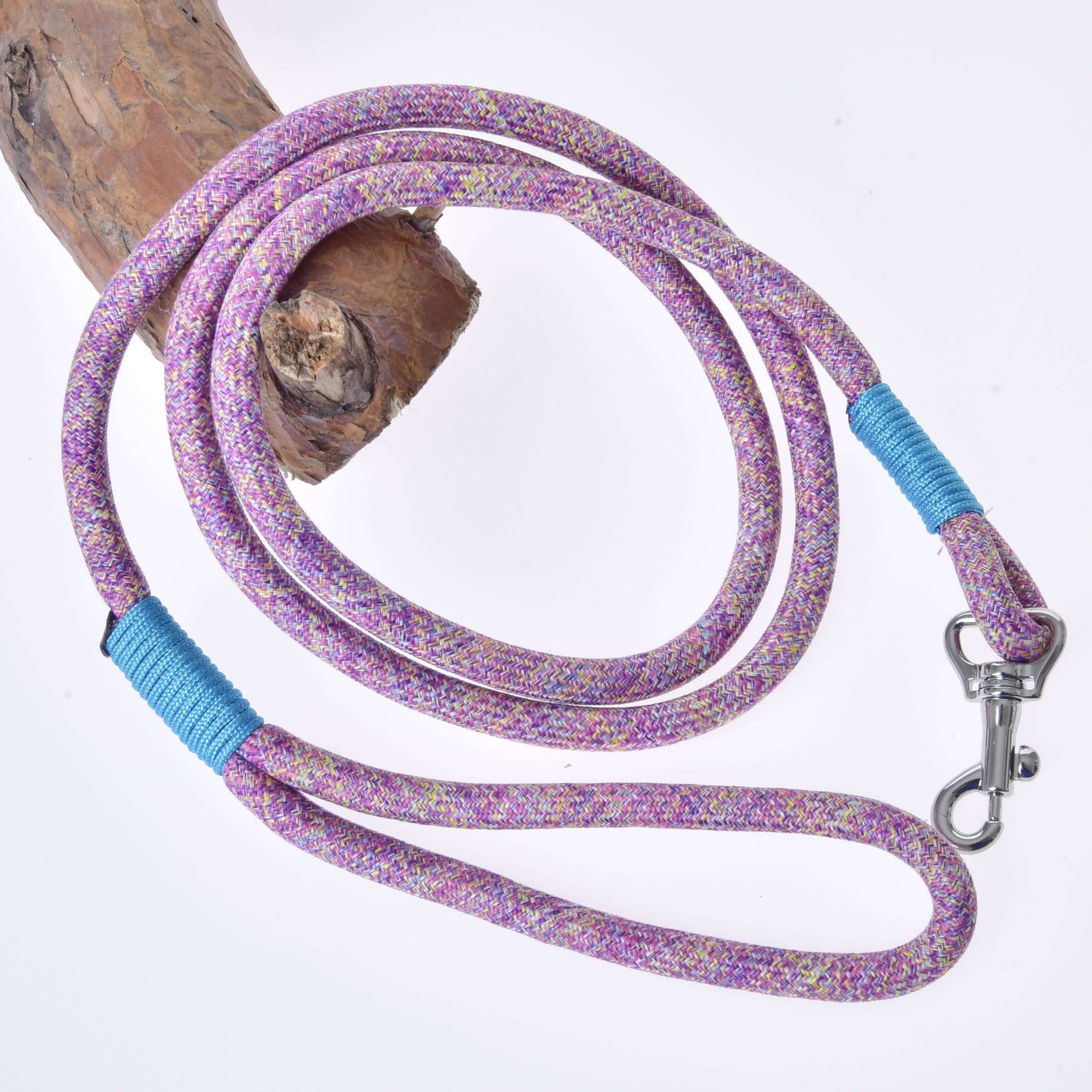 Hobby Horse - Longe Bubble de Hobby Horse LarDen, longe violette et rose avec accents bleus et mousqueton en métal, enroulée sur une branche en bois clair et présentée sur fond blanc.