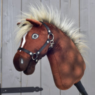 Gros plan sur Hobby Horse Cinnamon avec Licol noir - taille S de Hobby Horse LarDen, avec corps en peluche marron, crinière duveteuse et licol noir, rappelant un fier étalon, sur fond en bois.