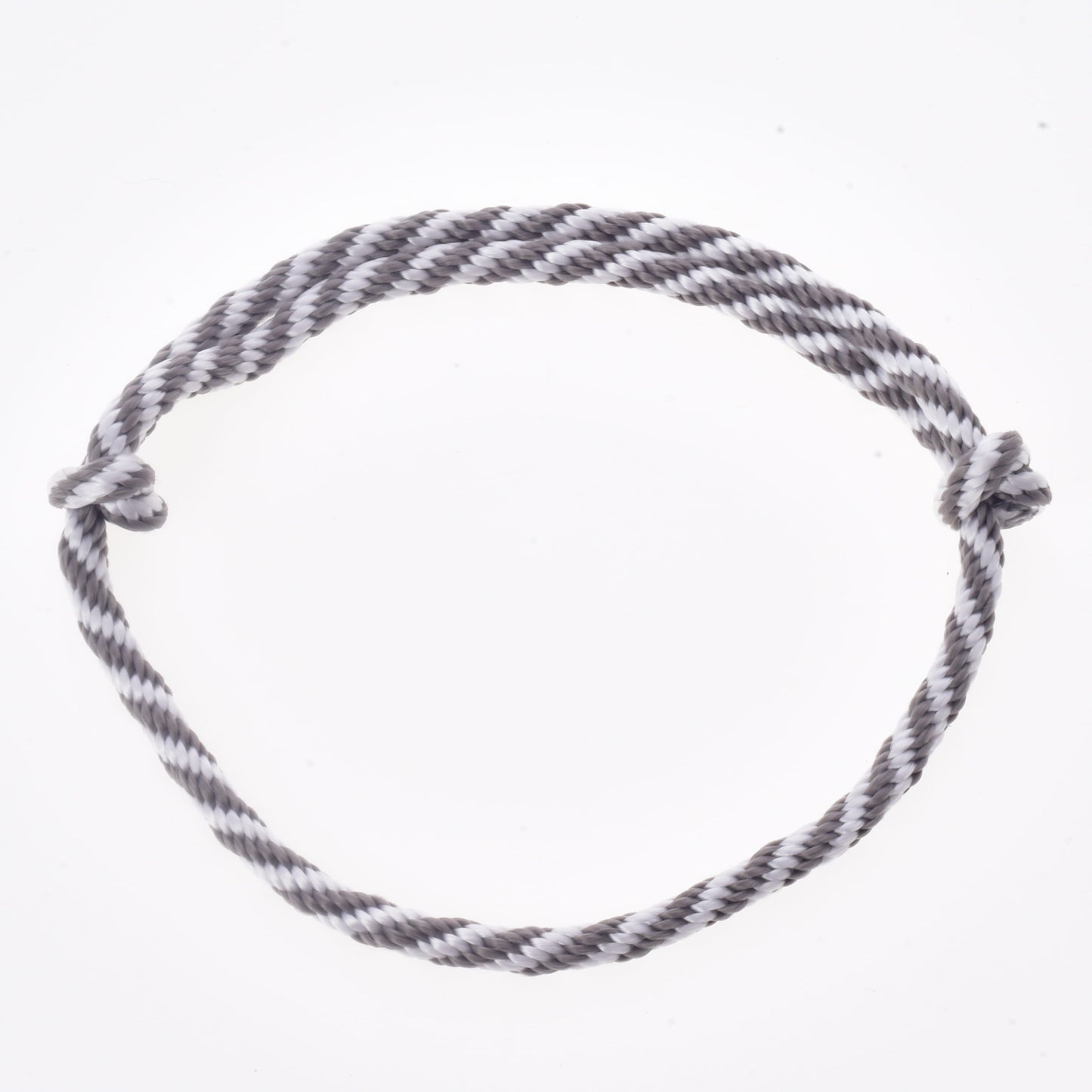 A gray and white twisted rope, forming a circle with simple knots at each end and set against a plain white background, makes up the "Set Start Silver" (halter + cordeo + lead rope + reins) from Hobby Horse LarDen—ideal for use as reins or halter and leash accessories for your hobby horse.