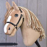 Hobby Horse Bren mit Schwarzem Halfter von Hobby Horse LarDen mit hellbraunem Körper, weißen Gesichtszeichnungen und langer Garnmähne vor Holz-Hintergrund.