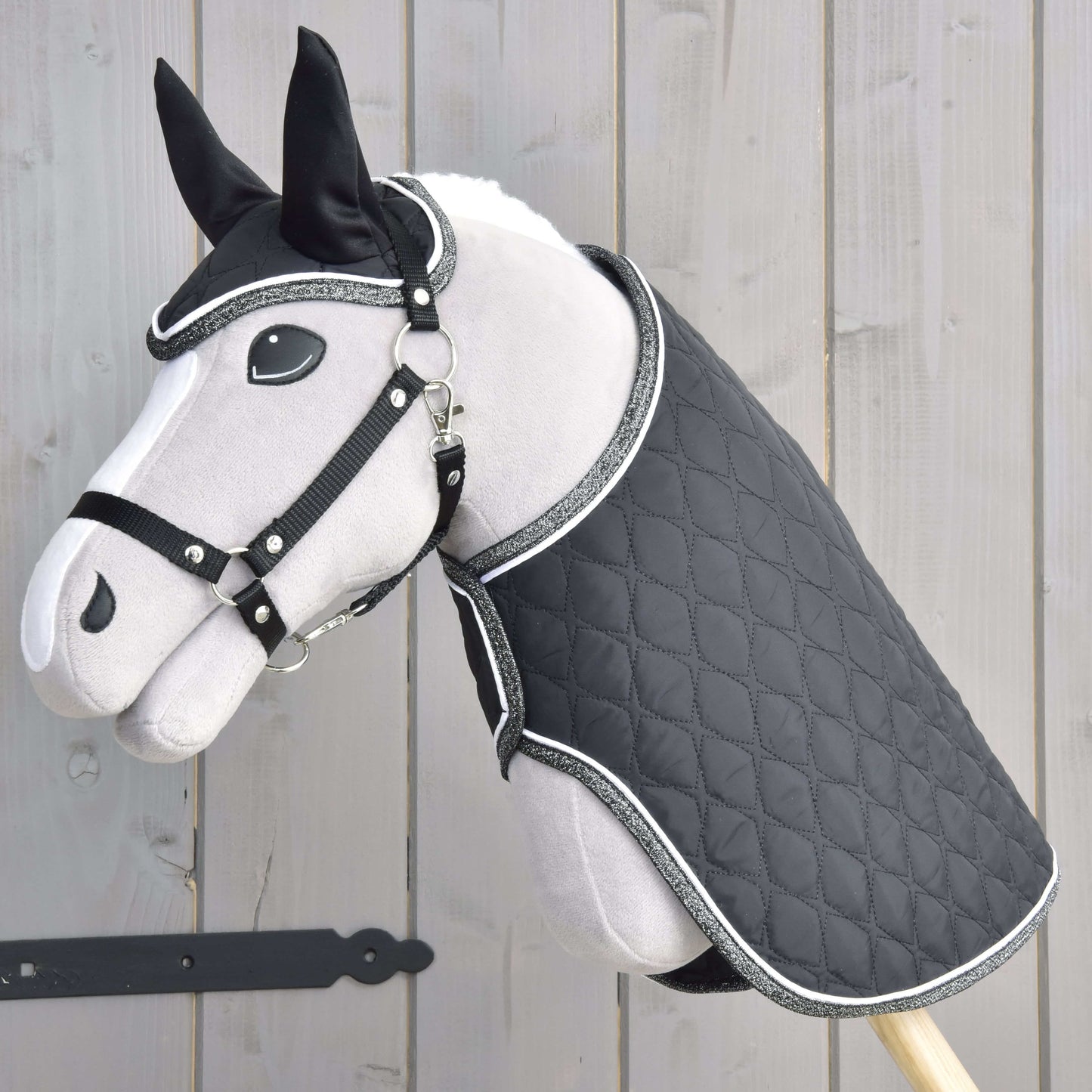Set Thermo Black Queen von Hobby Horse LarDen als plüschiges Hobby Horse mit gesteppter schwarzer Decke und passendem Zaumzeug, perfekt als stilvolle Dekoration für Reitsportfans.
