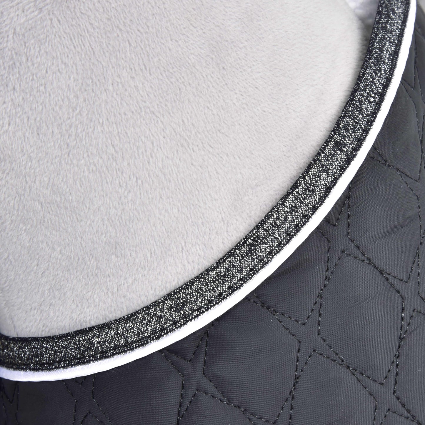 Nahaufnahme des Set Thermo Black Queen von Hobby Horse LarDen mit gestepptem schwarzem geometrischem Stoff und hellgrauem Plüsch, getrennt durch eine glitzernde schwarz-weiße Einfassung, ideal als eleganter Akzent für eine Hobby Horse-Decke oder Dekoration.