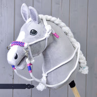 Seilset Weiß (Gr. M) von Hobby Horse LarDen an einem grauen Plüsch-Hobby Horse mit weißer Mähne, Zügeln und geflochtenem Halfter mit rosa und blauen Akzenten vor Holzhintergrund.