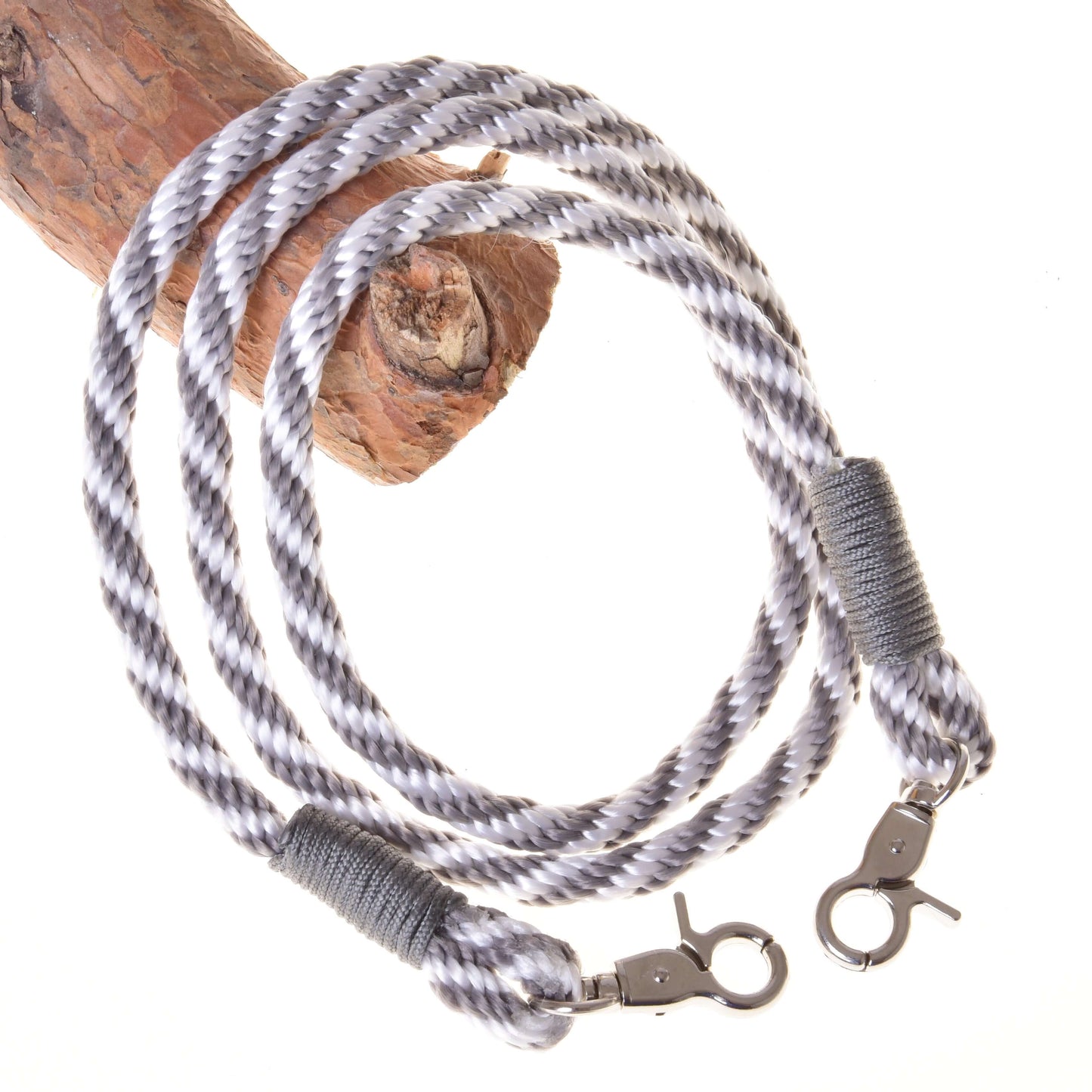Set Start Silber (Halfter + Halsring + Führstrick + Zügel) von Hobby Horse LarDen umfasst ein Halfter, einen Halsring, einen Führstrick und Zügel – grau-weiß gedrehtes Seil mit Metallverschlüssen – perfekt für deine Hobby Horse Kollektion. Auf Holz geschlungen vor weißem Hintergrund gezeigt.