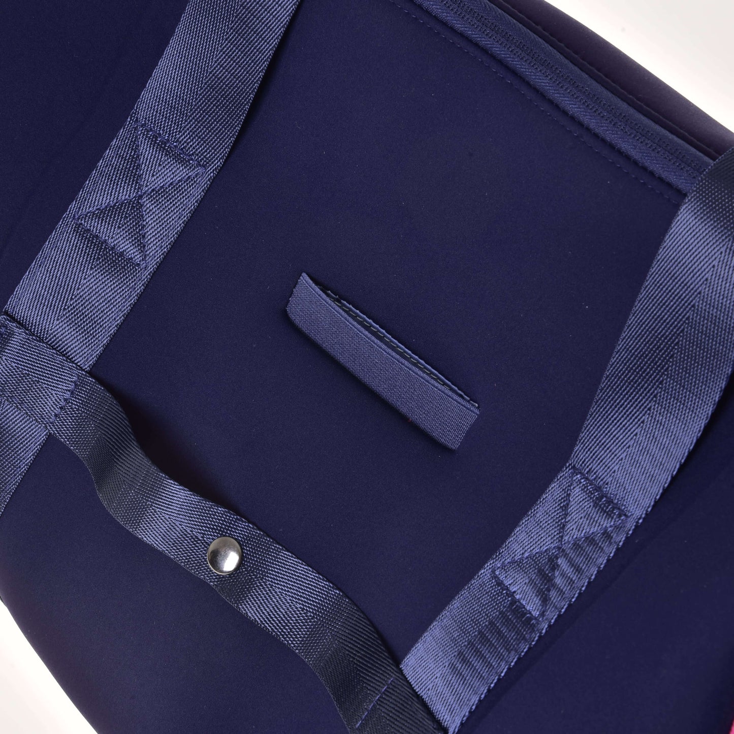 Gros plan du Sac de sport LarDen bleu foncé de Hobby Horse LarDen avec poignées bleues assorties, sangle réglable et bouton-pression argenté. Les coutures visibles et la texture des poignées soulignent sa praticité pour un usage quotidien.