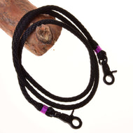 Rênes Violette de Hobby Horse LarDen, rênes noires tressées en polypropylène enroulées avec clips métalliques et attaches violettes, drapées sur du bois sur fond blanc, idéales comme rênes artisanales pour Hobby Horse.