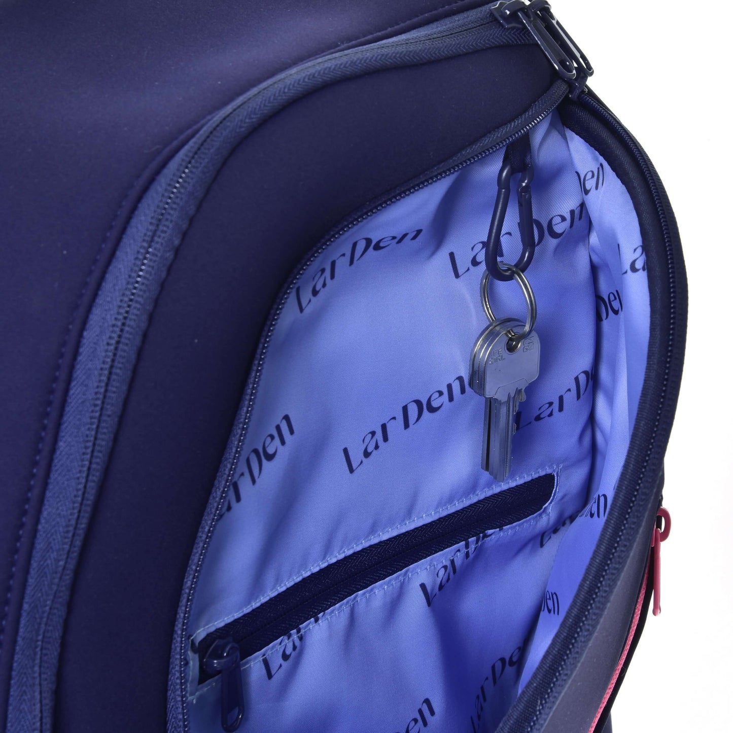 Gros plan sur un sac à dos Hobby Horse LarDen ouvert de Hobby Horse LarDen, montrant un intérieur bleu clair avec poche zippée, bretelles rembourrées et porte-clés tenant deux clés.