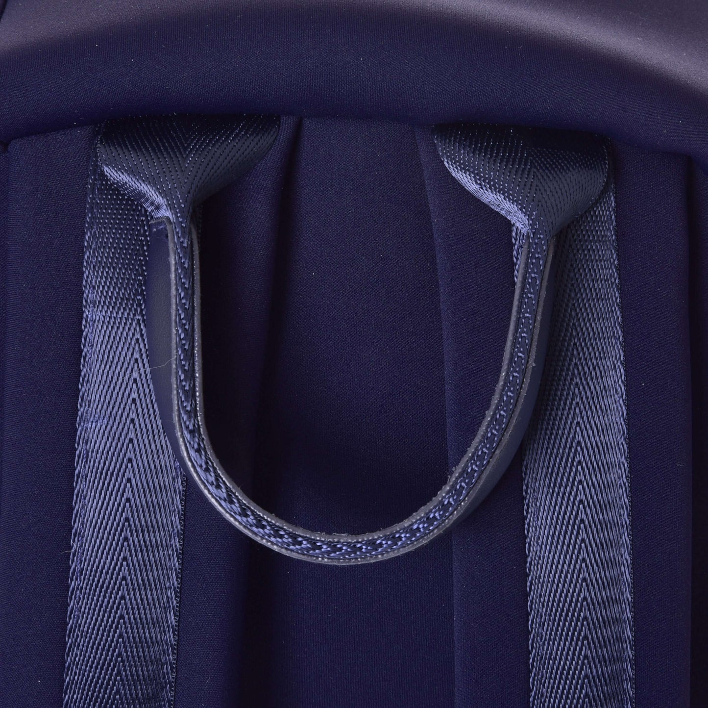 Gros plan sur le sac à dos Hobby Horse LarDen de Hobby Horse LarDen, en néoprène bleu foncé, avec deux bretelles rembourrées et une poignée de transport supérieure robuste.