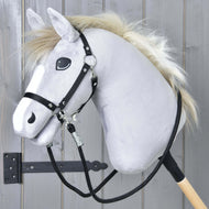 Hobby Horse LarDen Hobby Horse - Zügel schwarz mit plüschigem grauem Kopf, schwarzem Zaumzeug für Hobby Horse, Paracord-Zügeln und weißer Mähne auf einem Holzstab, präsentiert vor grauen Holzpaneelen mit sichtbarem schwarzem Metallscharnier.