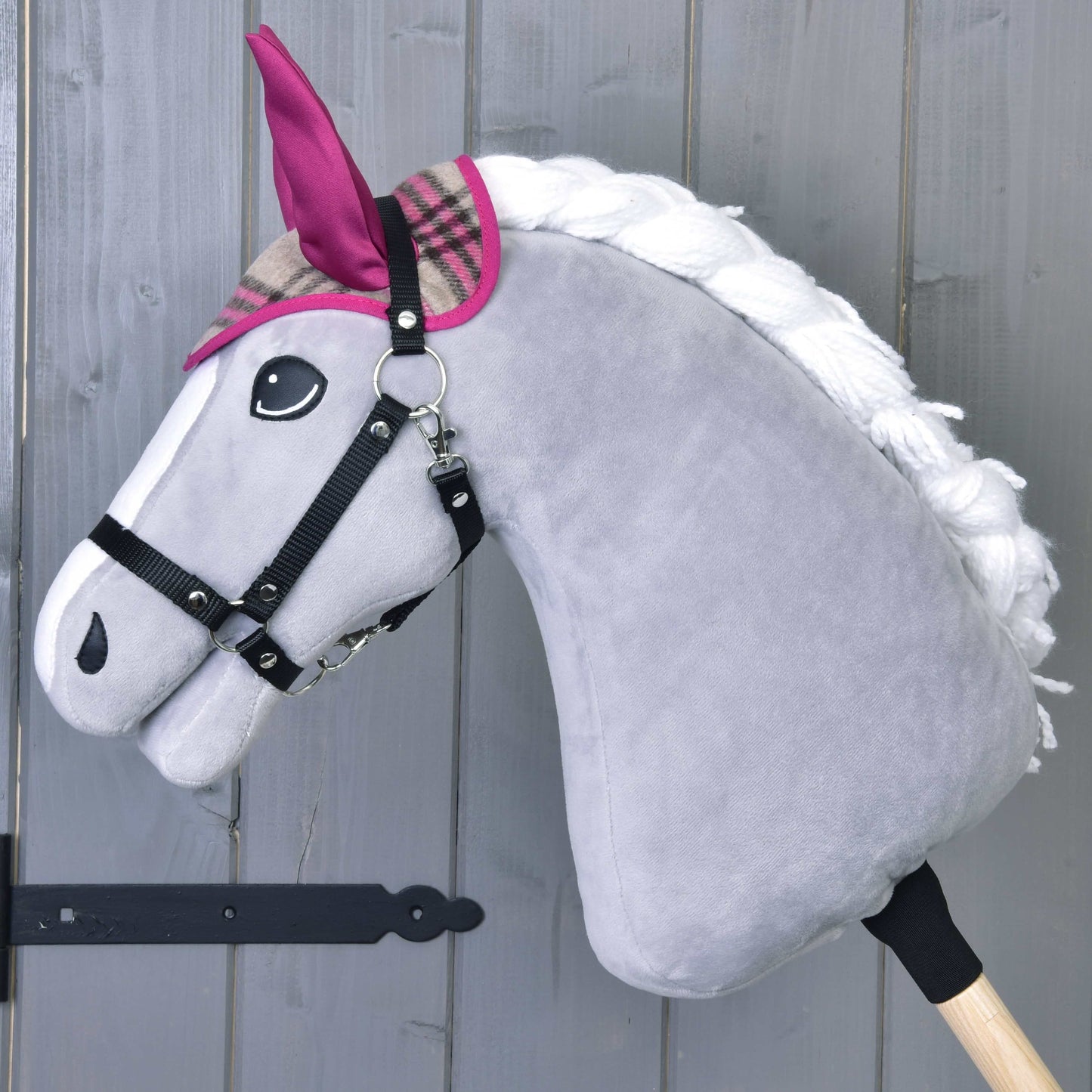 Hobby Horse en peluche gris de LarDen avec crinière blanche, oreilles roses à carreaux et bride noire sur un bâton en bois, idéal pour accompagner l’Ensemble Cube Rose lors de jeux douillets.