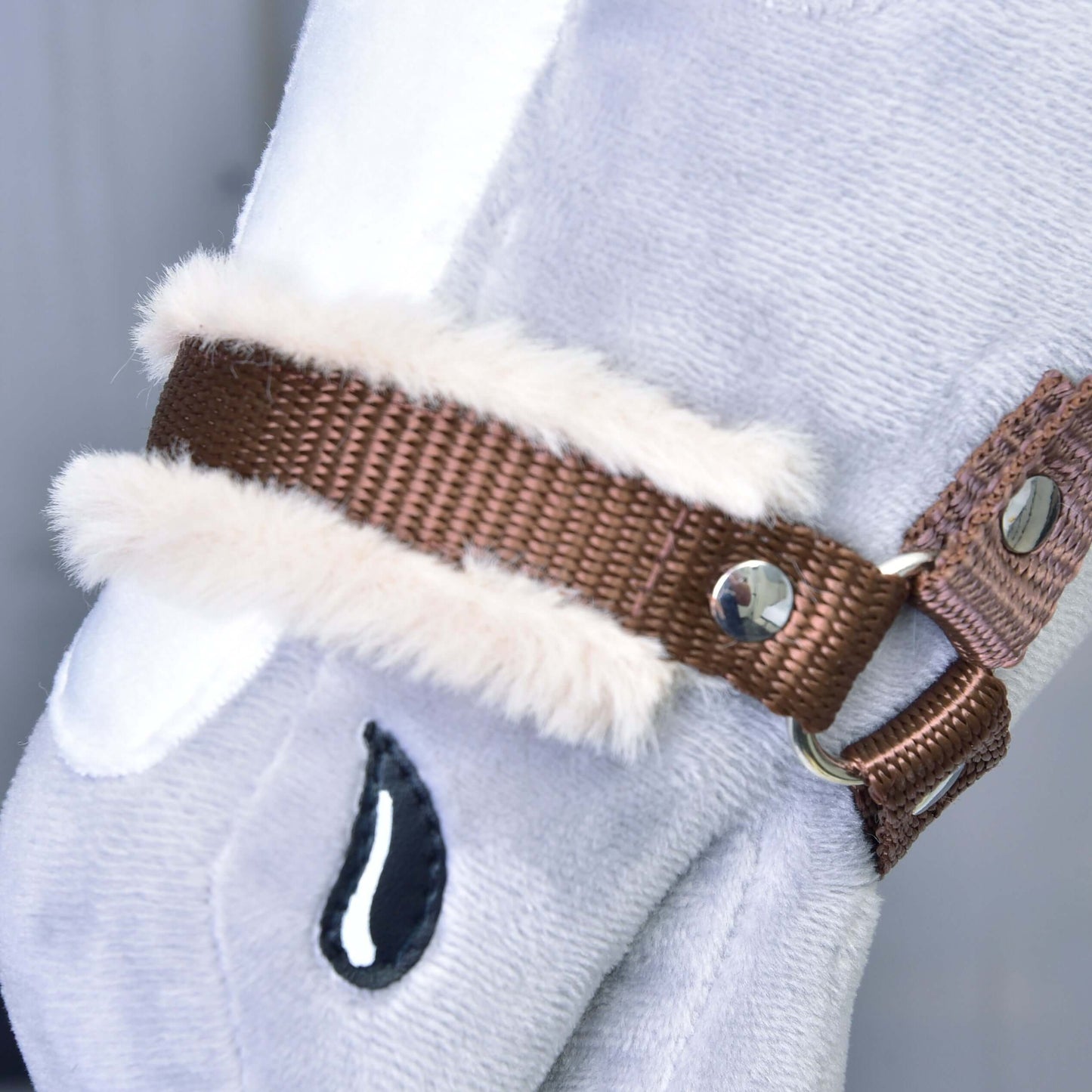 Gros plan sur le Licol marron avec fourrure de Hobby Horse LarDen, accessoire pour Hobby Horse en peluche gris clair avec licol marron, bordure en fausse fourrure blanche, rivets métalliques et détail noir cousu en forme de goutte.