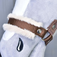 Nahaufnahme von Hobby Horse LarDen „Halfter braun mit Fell“, einem Accessoire für Hobby Horse aus hellgrauem Plüsch mit braunem Halfter, weißem Kunstfellbesatz, Metallnieten und einem aufgestickten schwarzen tropfenförmigen Detail.