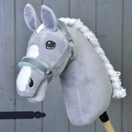 Hobby Horse LarDen Halfter grau mit mint Fell – ein Accessoire für Hobby Horse aus grauem Plüsch mit weißer Mähne und Gesichtsabzeichen – vor grauem Holzhintergrund.