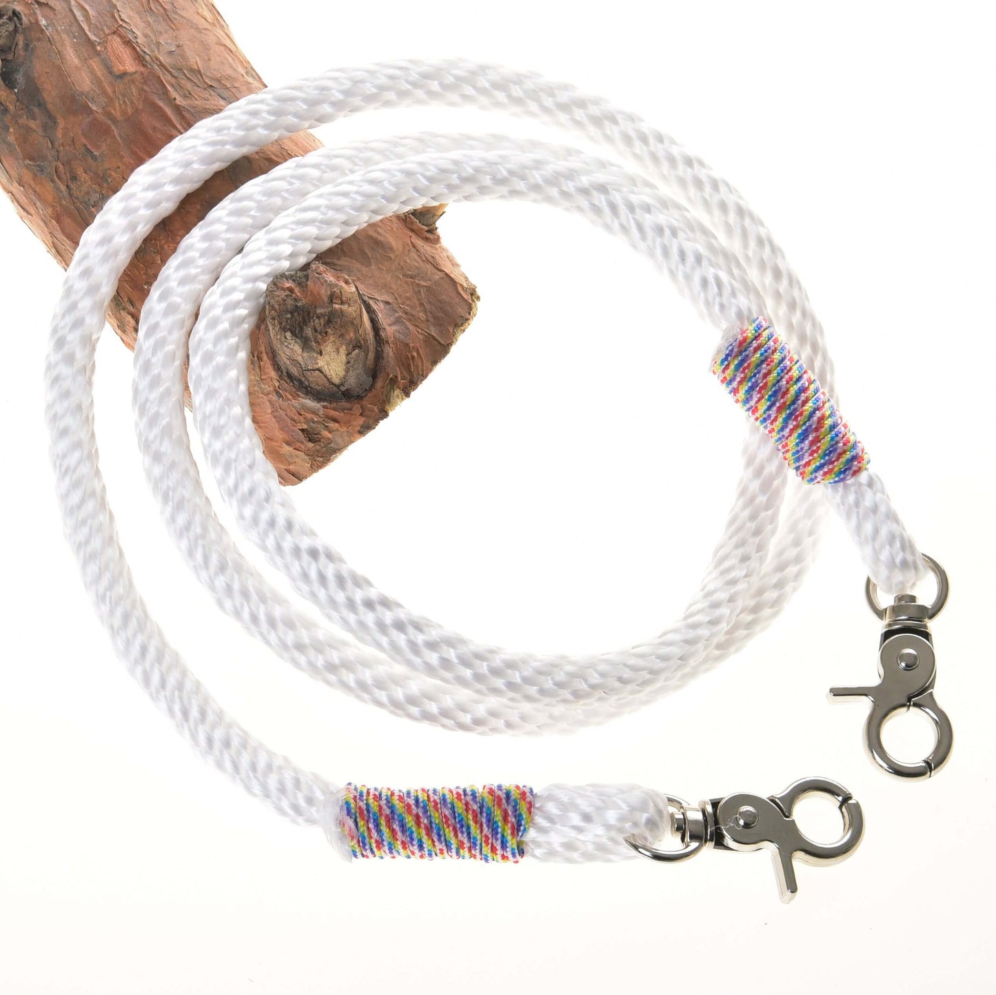 Rênes blanches de Hobby Horse LarDen avec mousquetons métalliques aux deux extrémités et fil multicolore près de chaque mousqueton, enroulées sur du bois sur fond blanc, évoquant l’apparence de rênes de bride sans mors de haute qualité.