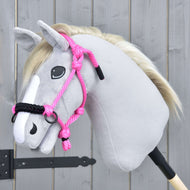 Hobby Horse LarDen Seilhalfter Pink, gezeigt auf einem plüschigen Hobby Horse mit hellgrauem Stoff, weißer Mähne und weißer Blesse, vor einem Holzhintergrund.