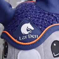 Close-up of a gray plush toy wearing the Hobby Horse LarDen “Ear bonnet crocheted Blue Sport” with orange trim and white horse head logo. The blue bonnet, used for insect protection on horses, features embroidered eyes on the plush toy.
