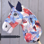 Combinaison de protection Hobby Horse Bleu Jungle (Lycra) de Hobby Horse LarDen, avec un motif abstrait vif rouge, blanc, violet et bleu, des yeux noirs et des oreilles foncées. Comprend une housse lavable et est présentée sur un bâton en bois près d’un mur gris.