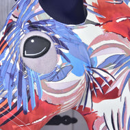 Gros plan sur la combinaison de protection Hobby Horse Bleu Jungle (Lycra) de Hobby Horse LarDen avec un motif animal abstrait coloré, un grand œil gris et des motifs tourbillonnants. La housse lavable est présentée sur un fond gris légèrement flou, parfait pour les amateurs de hobby horse.