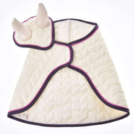 Set Supreme Crema von Hobby Horse LarDen ist ein gesteppter cremefarbener Überzug mit lila Einfassung und rosa Akzenten, der sich gemütlich um den Körper legt und hornartige Fliegenhauben besitzt. Flach liegend vor weißem Hintergrund.