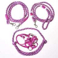 The Set Start Pink by Hobby Horse LarDen includes a pink halter, cordeo, lead rope, and braided reins with metal clips, all arranged on a white background. Perfect as hobby horse accessories.