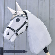 The Hobby Horse LarDen plush gray hobby horse wears the Ear bonnet Cremo England and a black halter, mounted on a wooden stick in front of a light gray wooden fence.
