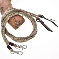 Offene Westernzügel Dallas von Hobby Horse LarDen sind ein beigefarbenes, aufgewickeltes geflochtenes Seil mit Lederakzenten und zwei Metall-Karabinerhaken an den Enden, drapiert über Holz vor weißem Hintergrund.