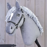 Hobby Horse LarDen „Hobby Horse Grace mit Schwarzem Halfter“ mit grauem Dutch-Warmblood-Design, weißer Garnmähne, weißer Kopfzeichnung, abgebildet vor einer Holzwand.
