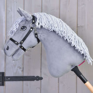 Hobby Horse Grace mit Schwarzem Halfter von Hobby Horse LarDen, ein graues Dutch Warmblood mit Garnmähne, auf einem Holzstab montiert und vor einer Wand aus Holzpaneelen dargestellt.